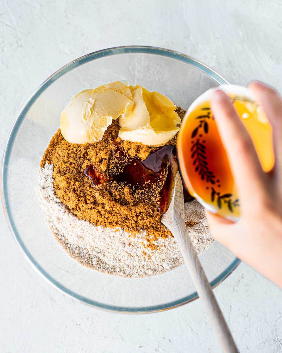 Ingredients for refined sugar free gingerbread cookies being poured into one bowl.