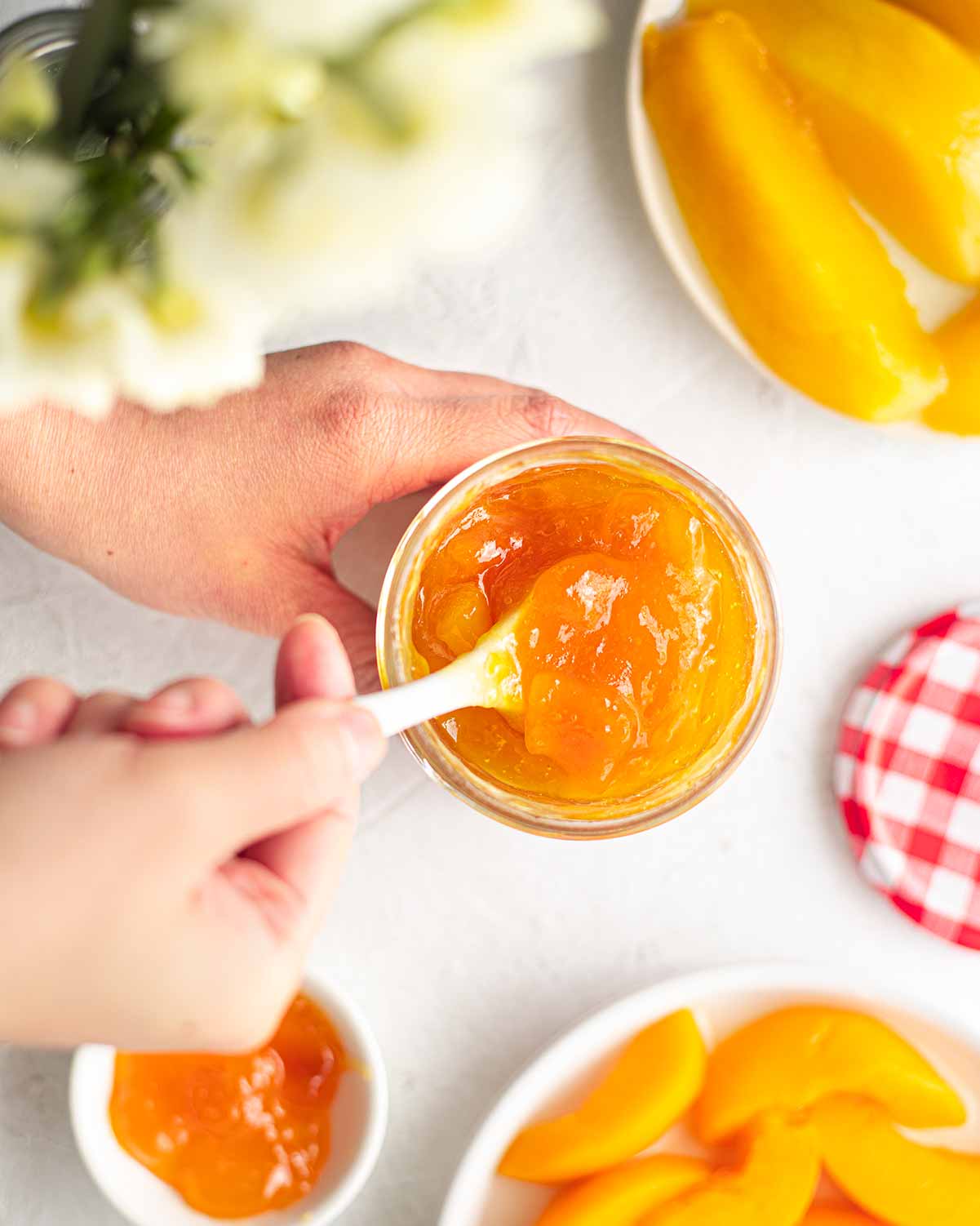 Spoon scooping peach mango conserve.