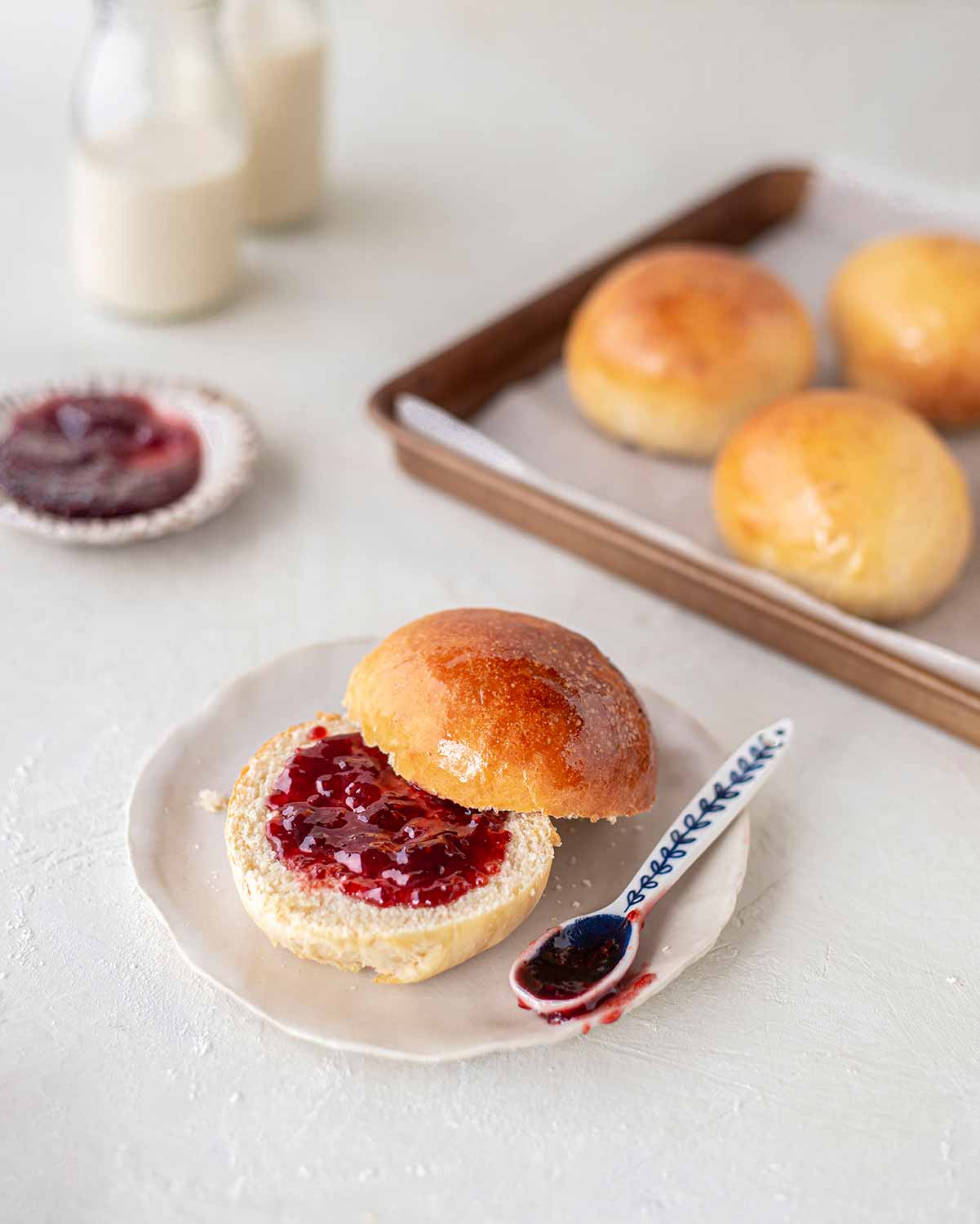 Brioche bun cut into half spread with raspberry jam.