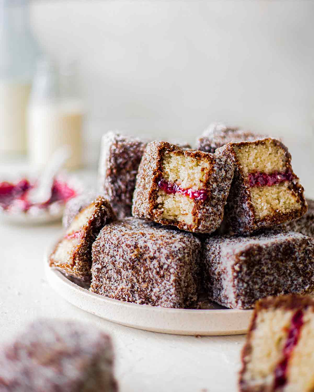 Stack of lamingtons showing shiny jam filling.