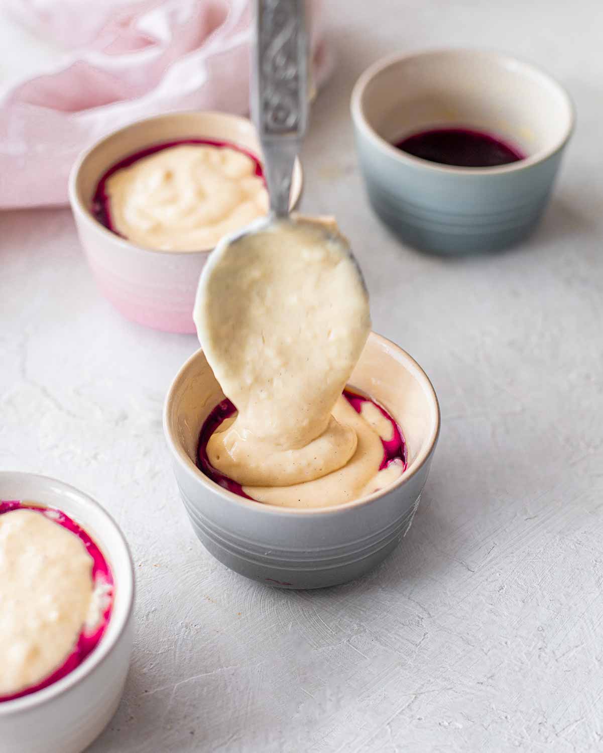 Spooning the pudding batter into the ramekins.