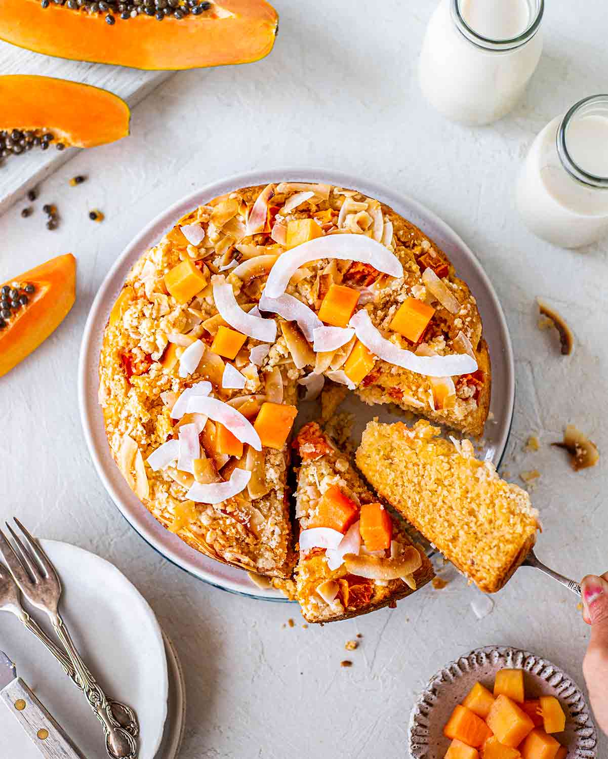 Overhead image of papapya coconut cake with two slices coming out.