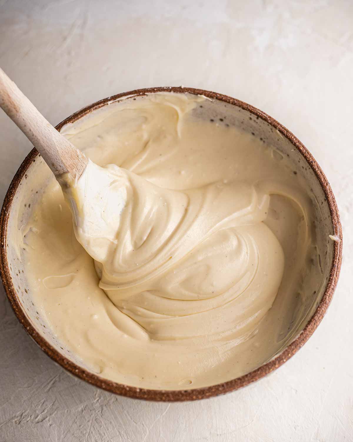 Vegan cream cheese frosting with spatula.