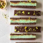 Row of chocolate mint bars showing 3 distinct layers revealing its 3 layers and chocolate topping.