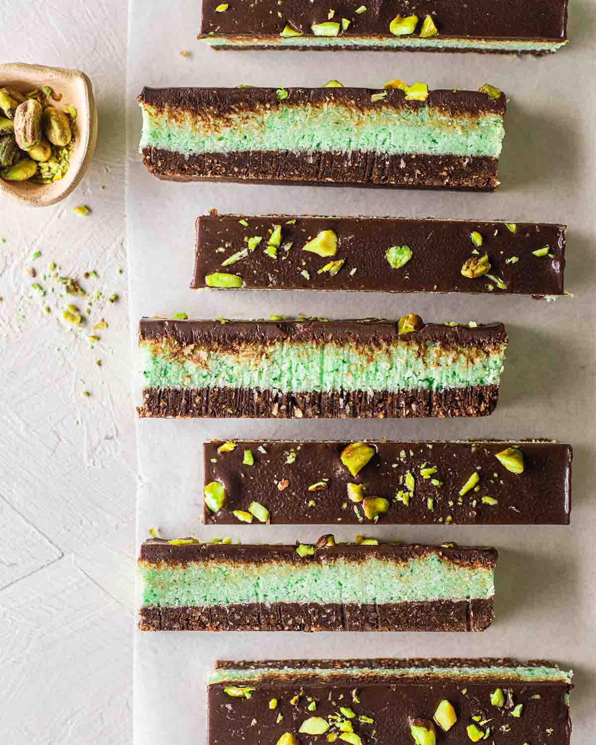 Row of chocolate mint bars showing 3 distinct layers revealing its 3 layers and chocolate topping.