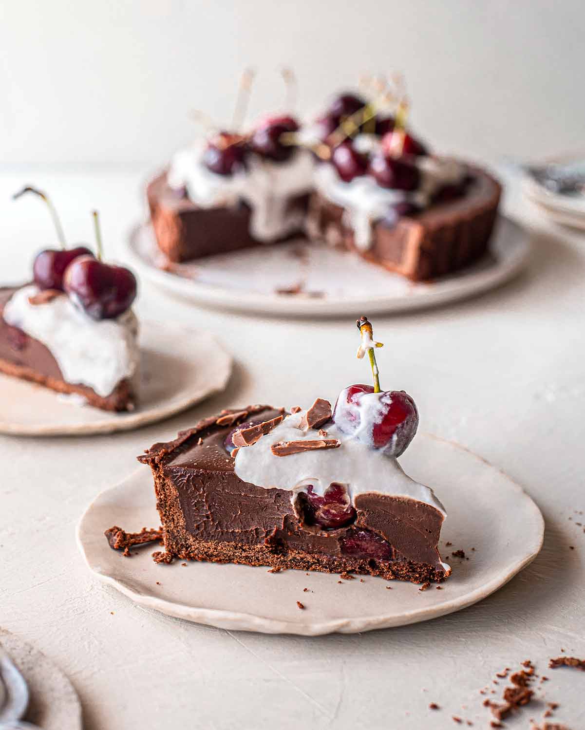 One slice of the black forest tart showing creamy and thick ganache filling and soft coconut cream on top. 