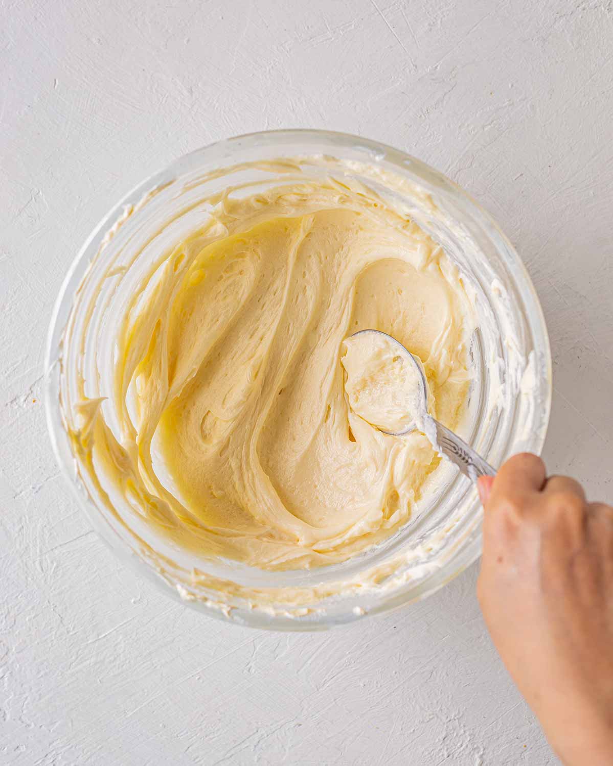 Thick cream cheese in glass bowl for vegan mango cake