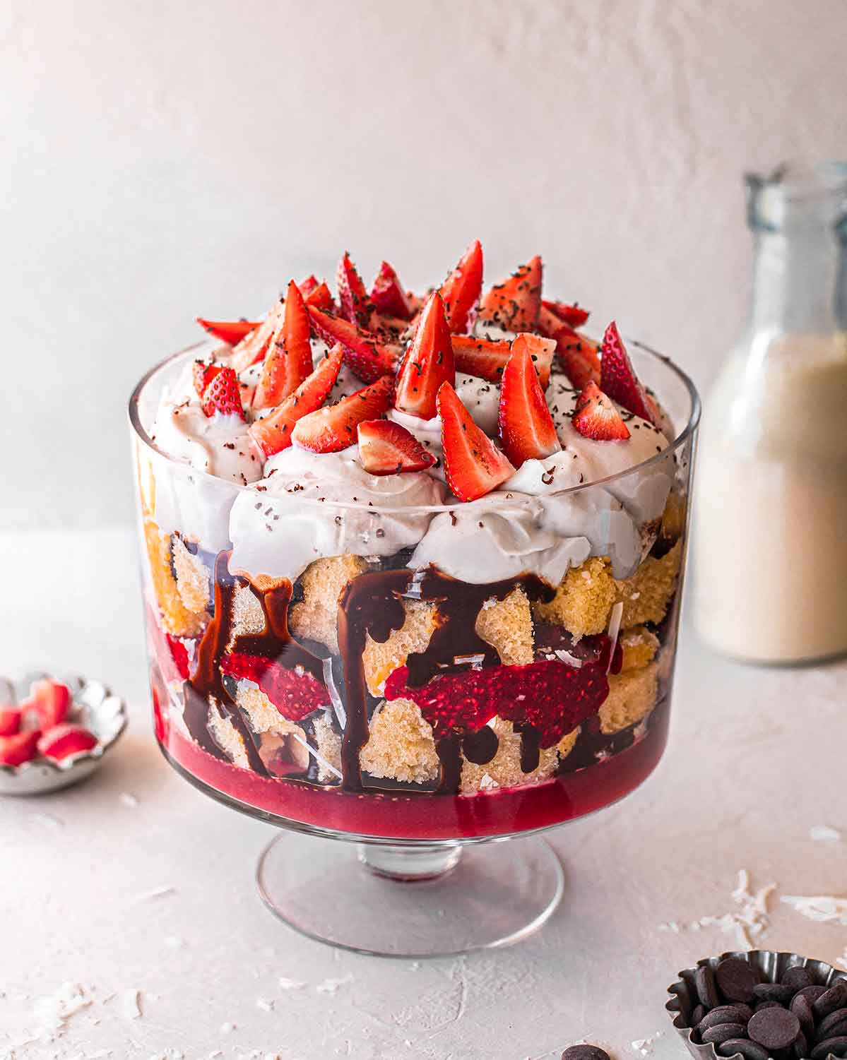 Lamington trifle in a tall clear glass showing different coloured and textured layers.