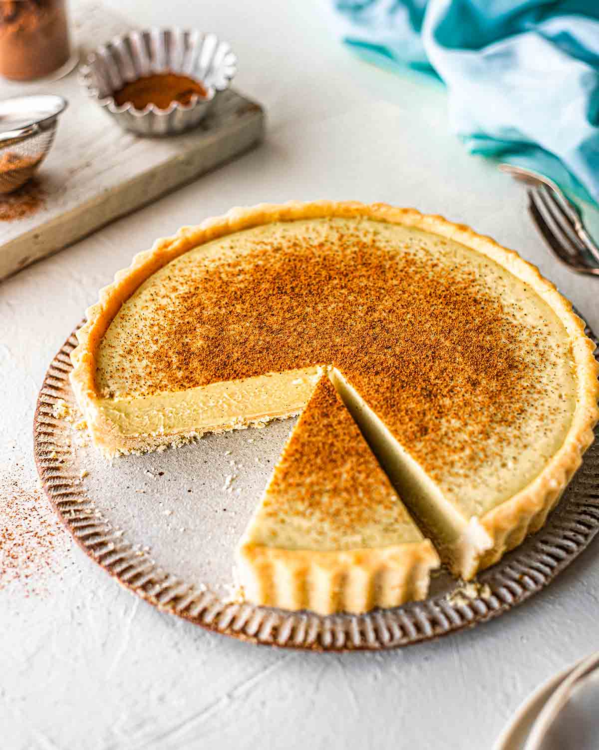 45 degree angle photo of vegan custard tart. Two slices taken out showing creamy and thick texture of custard pie.