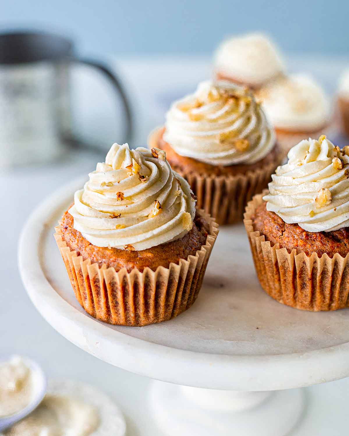 Easy vegan carrot cake cupakes with cream cheese frosting on cake stand.