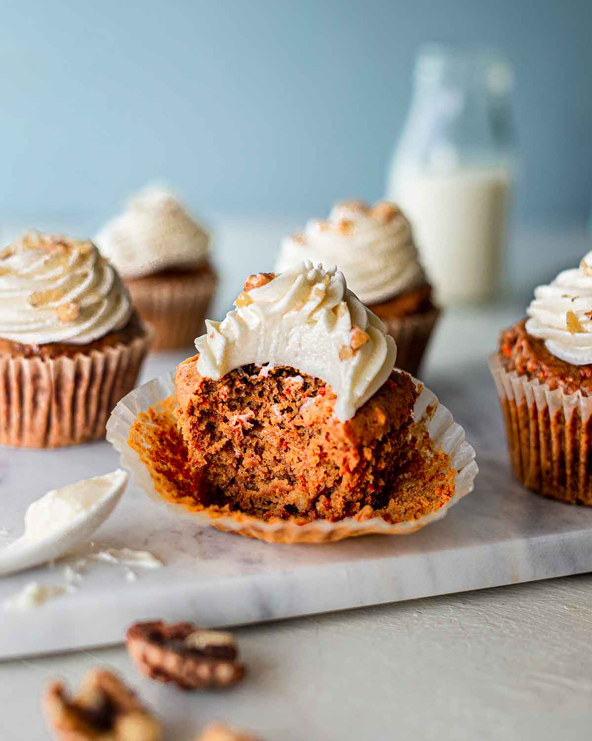 Bite shot of a vegan carrot cake cupcake revealing the moist and fluffy interior.
