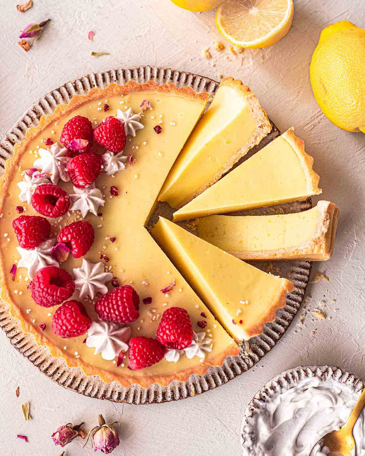 Lemon tart on plate with a few slices coming out showing texture.