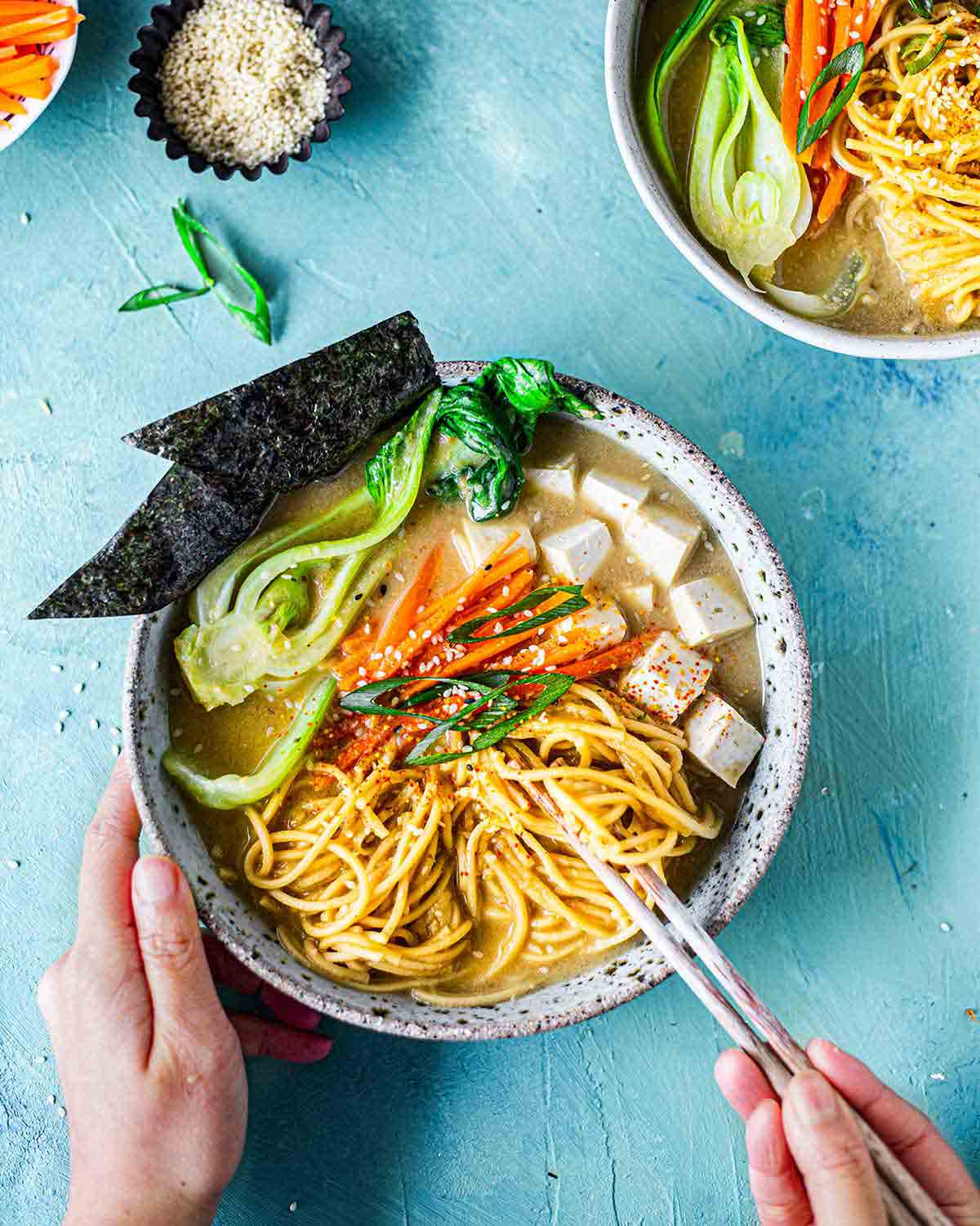 Hand holding chopsticks getting ready to easy vegan ramen.