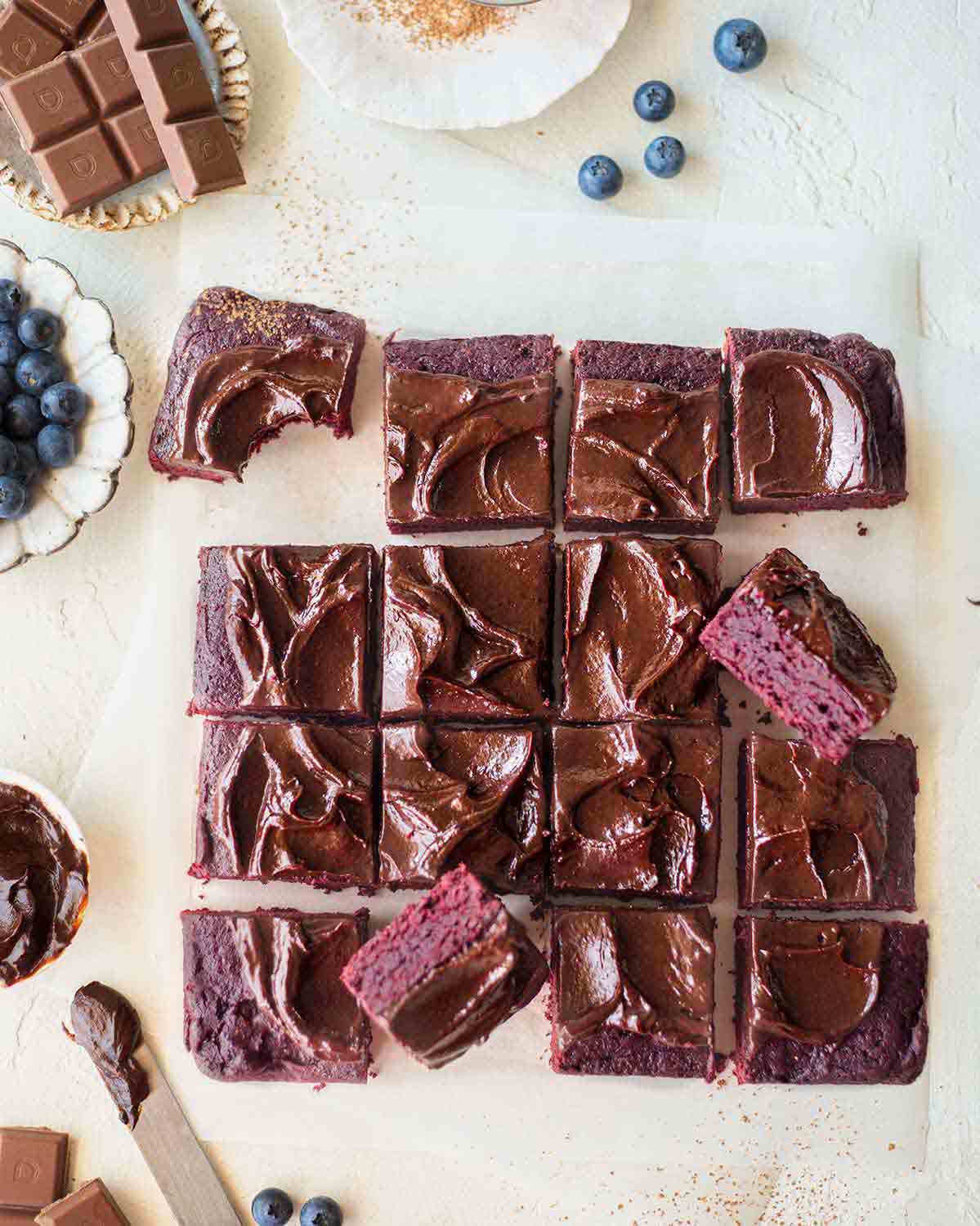 Flatlay of vegan beetroot brownies cut into squares.