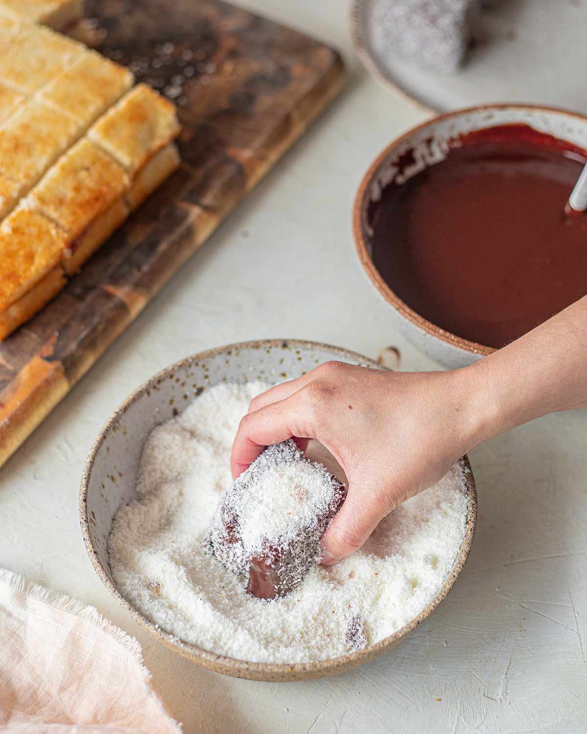 Dipping lamington into coconut.