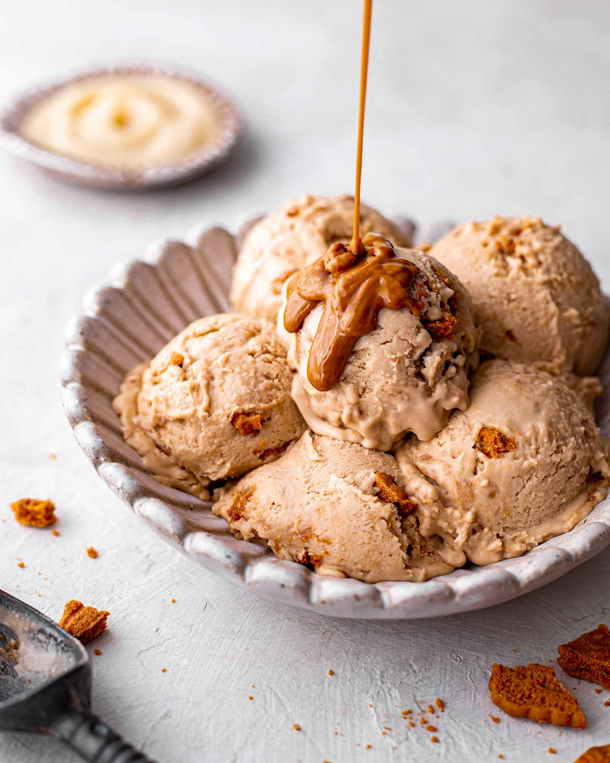 Close up of biscoff ice cream scooped into bowl with a drizzle of biscoff.