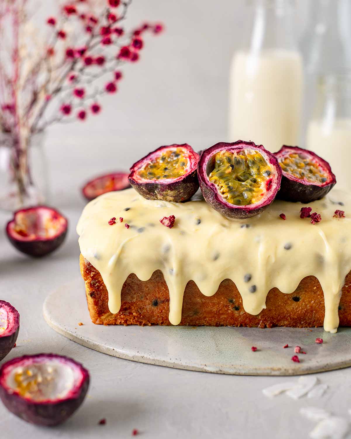 Side of vegan passionfruit cake with icing dripping down the sides.