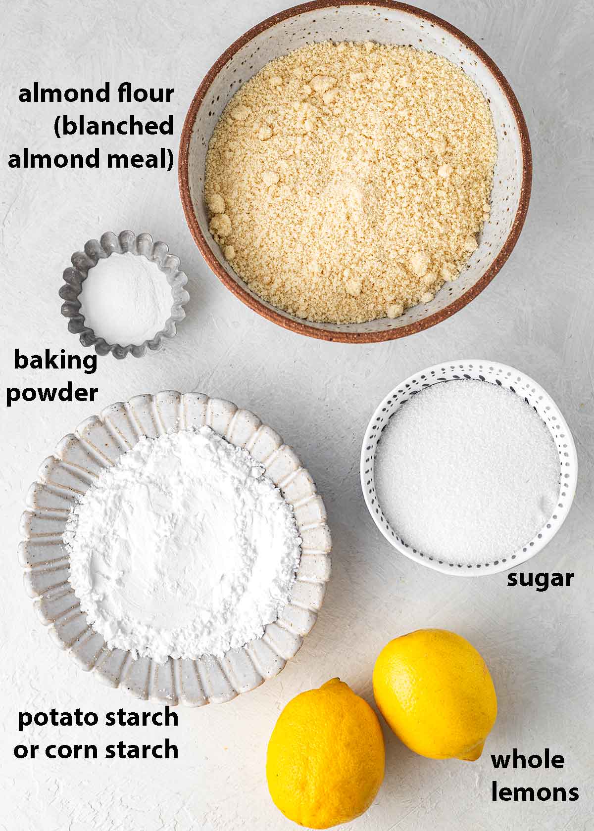 Flatlay of 5 key ingredients for whole lemon cake.
