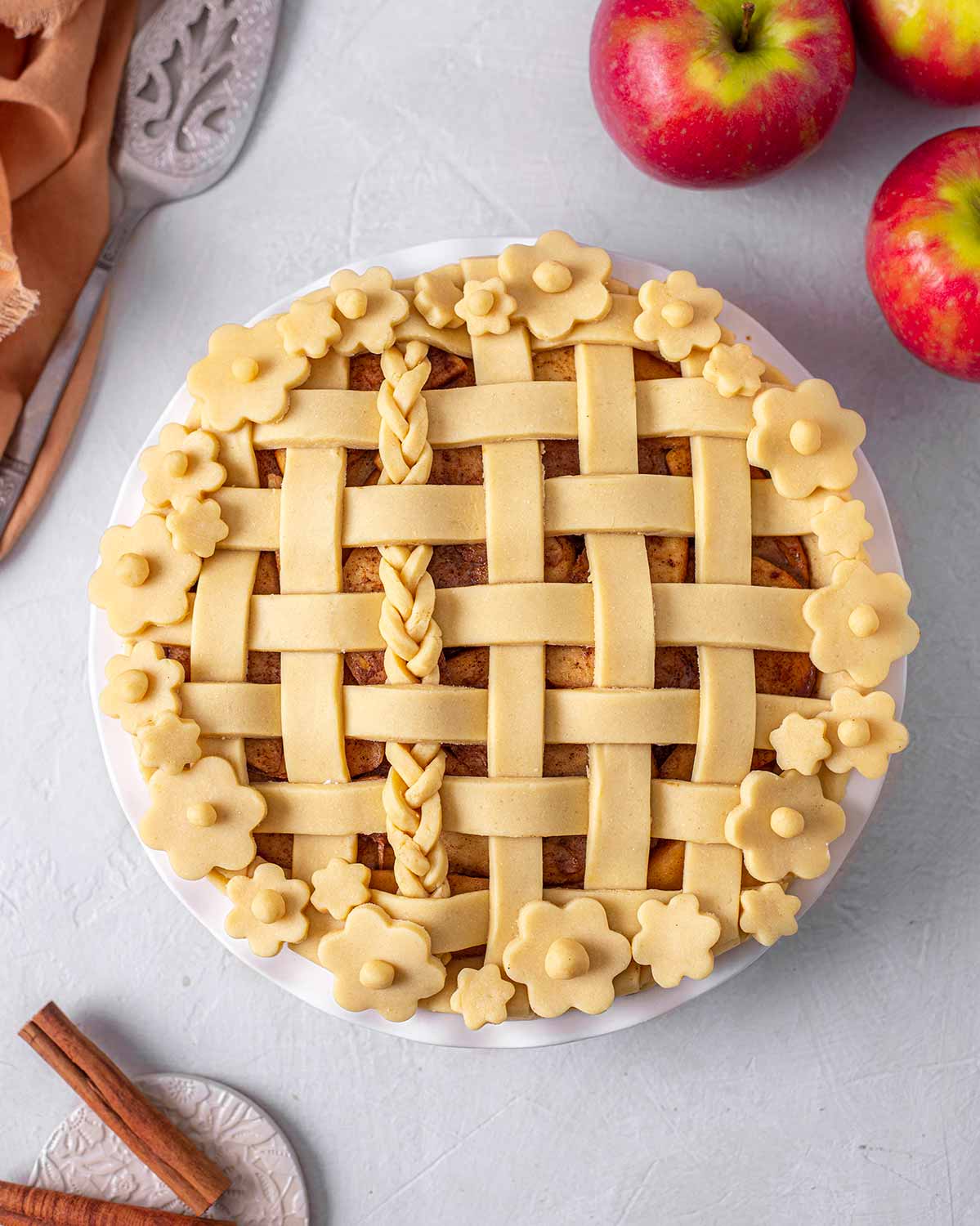 Unbaked apple pie surrounded by ingredients.
