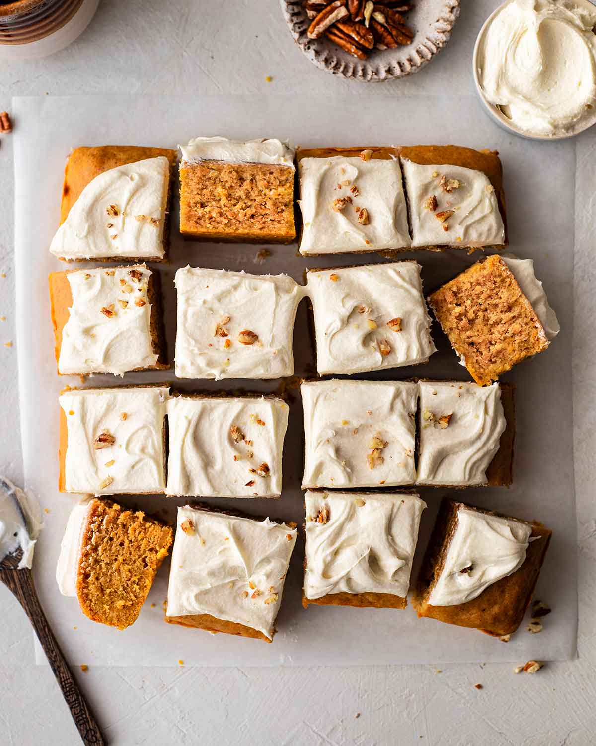 Flatlay of vegan sweet potato cake with creamy frosting cut into 16 squares.