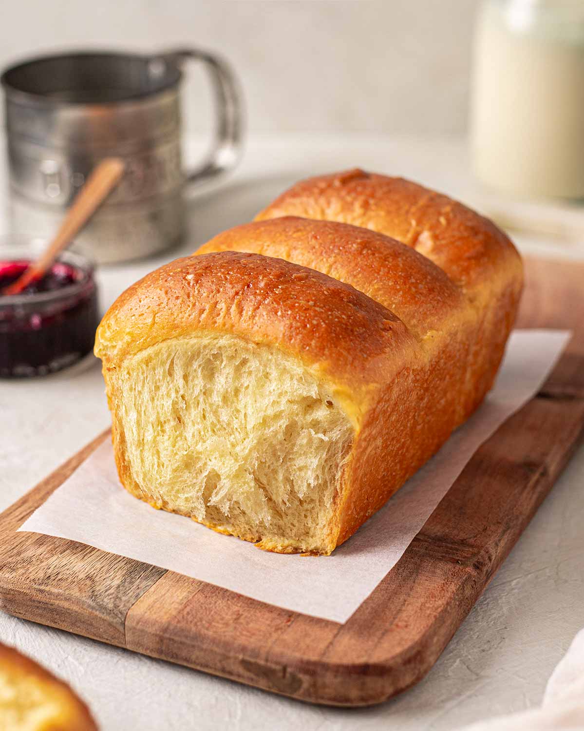 Buttery golden vegan brioche loaf on a serving board.