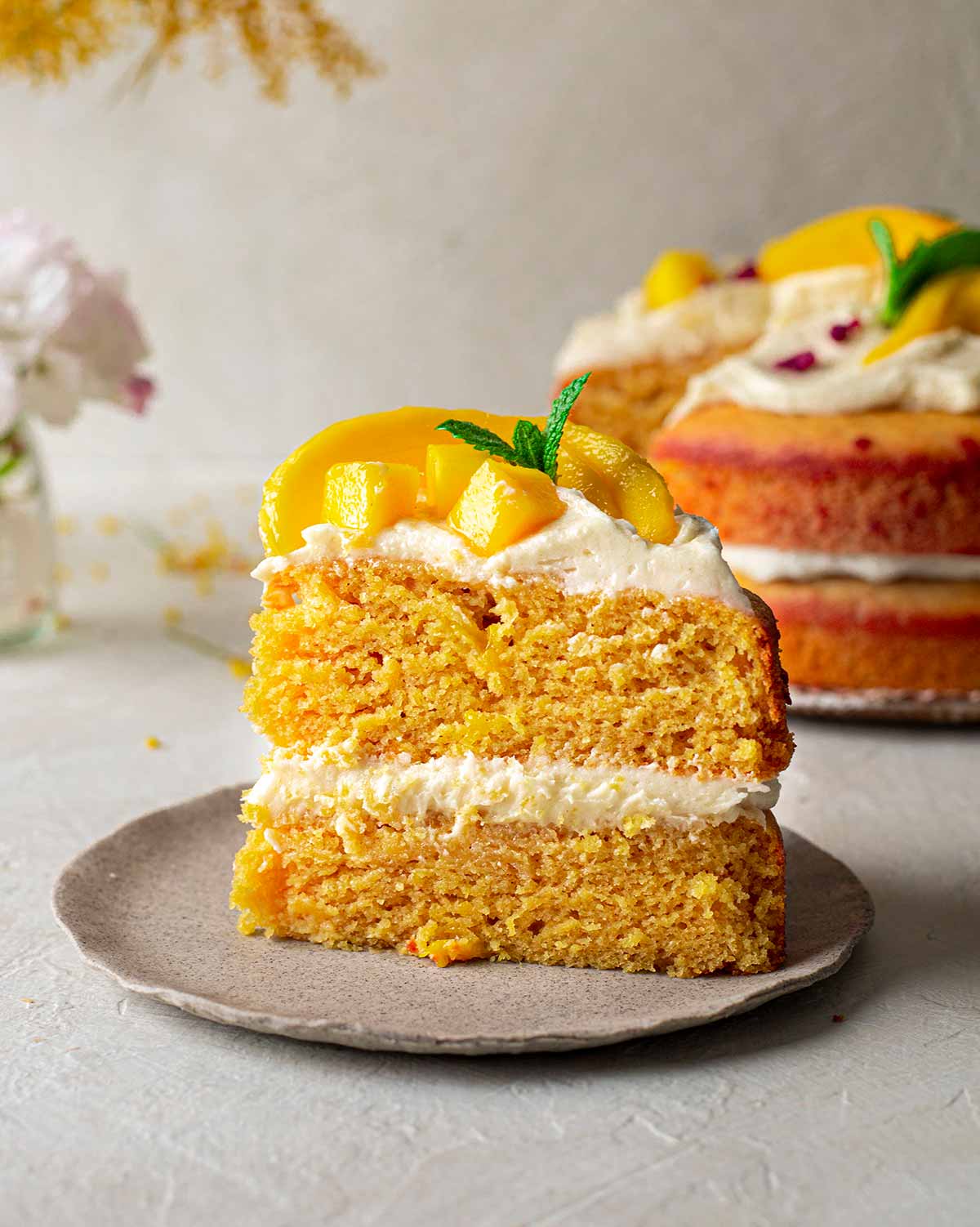 Slice of vegan mango cake showing fluffy and golden texture.