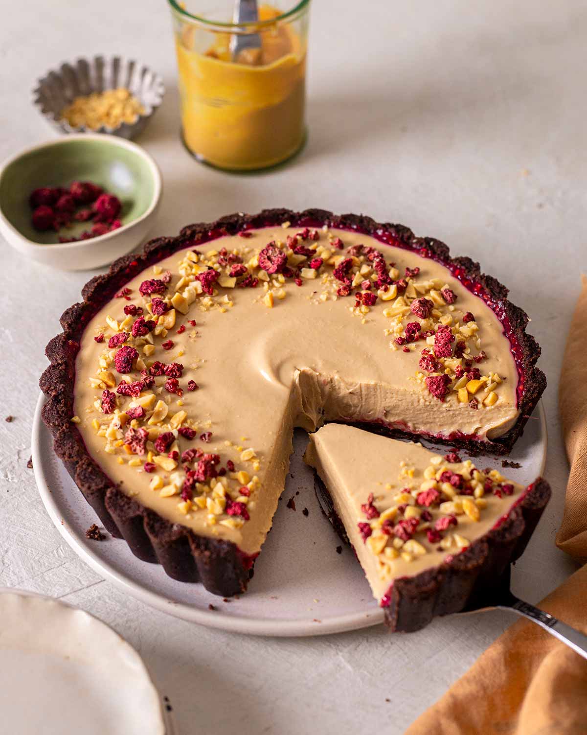 Peanut butter pie on plate with slice coming out showing soft mousse filling.