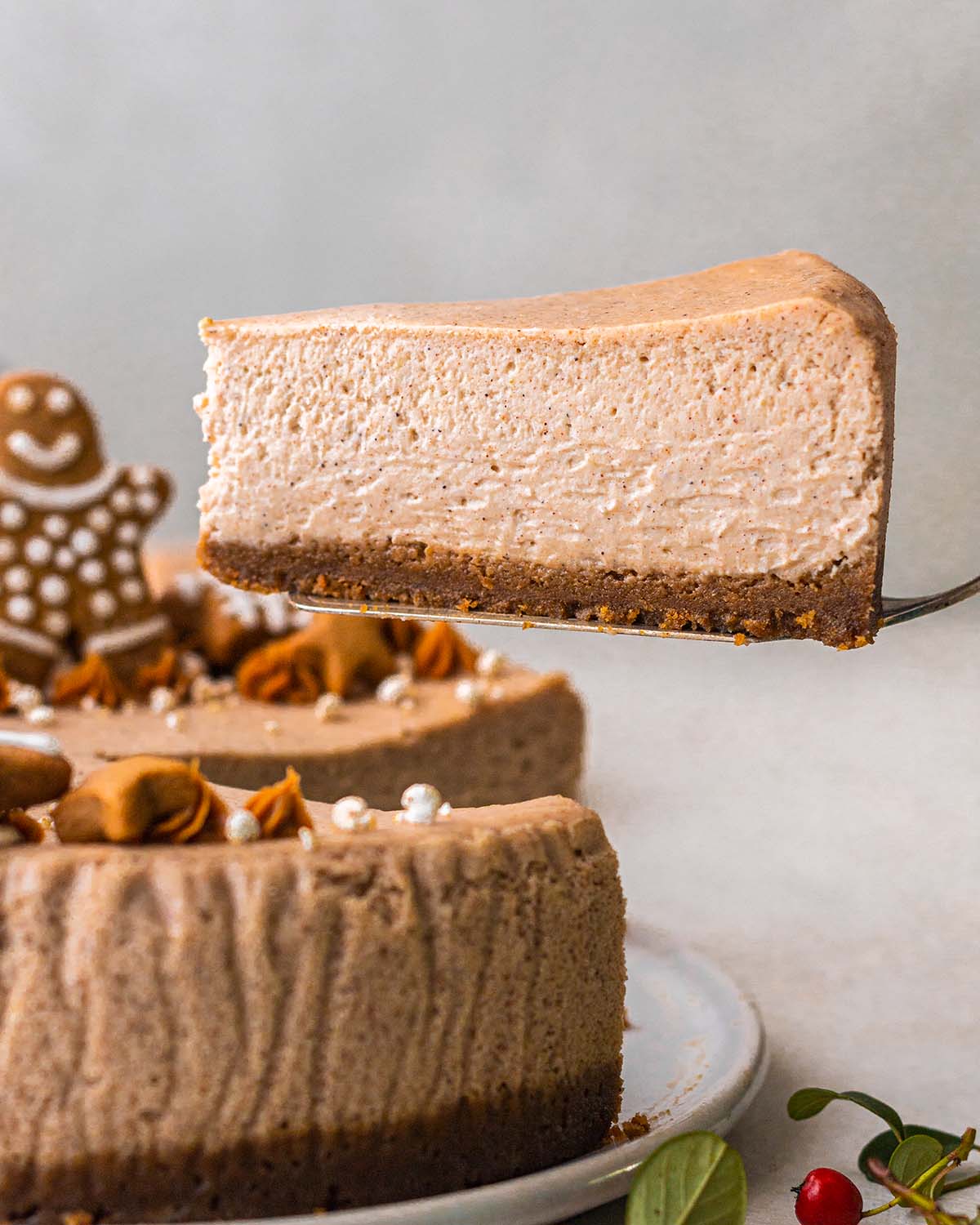 One slice of the gingerbread cheesecake lifted up showing creamy texture.
