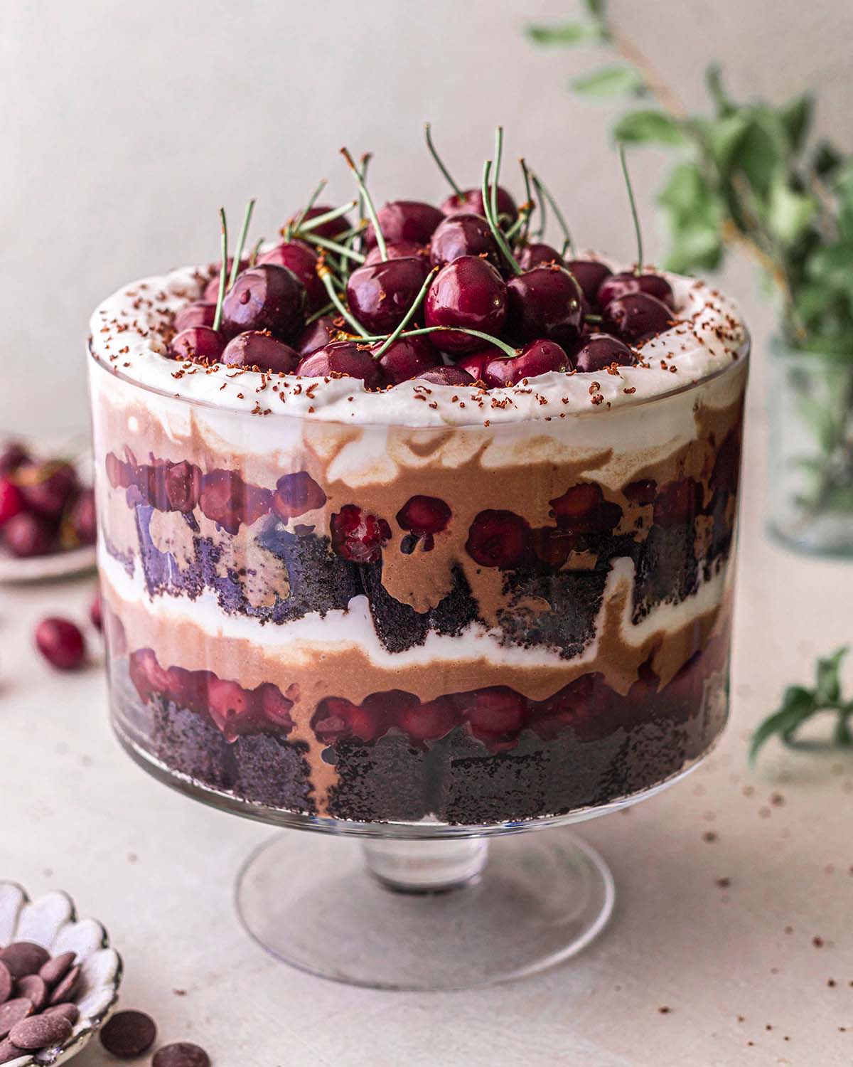 Vegan black forest trifle in large trifle dish showing lots of messy layers.