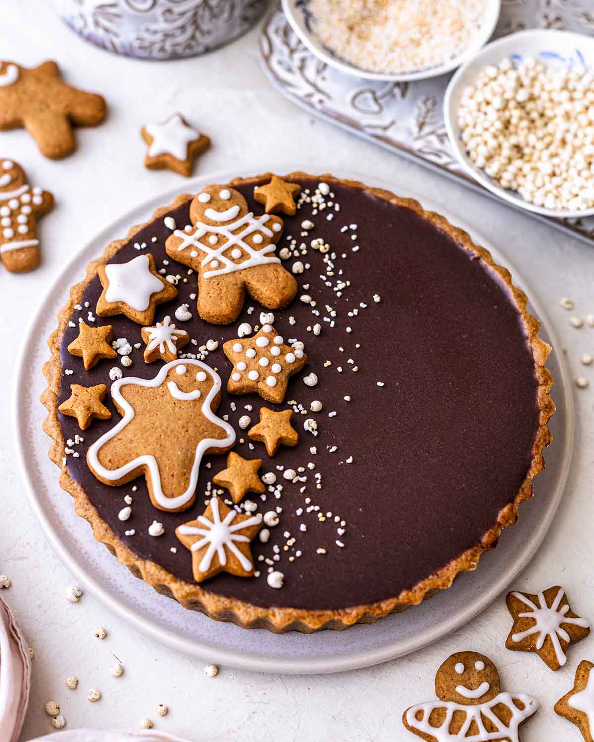 Side angle of decorated caramel tart with gingerbread on top.