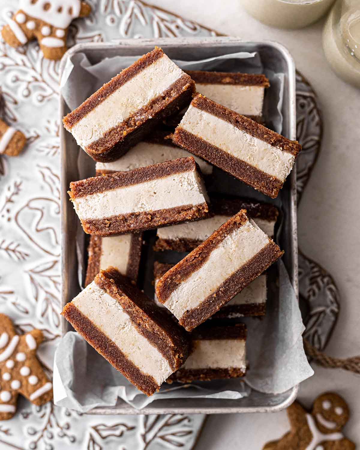 Stack of gingerbread ice cream sandwiches in lined loaf tin.