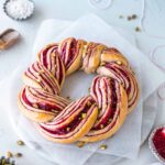 Raspberry and Pistachio Wreath on baking paper and marble serving board.