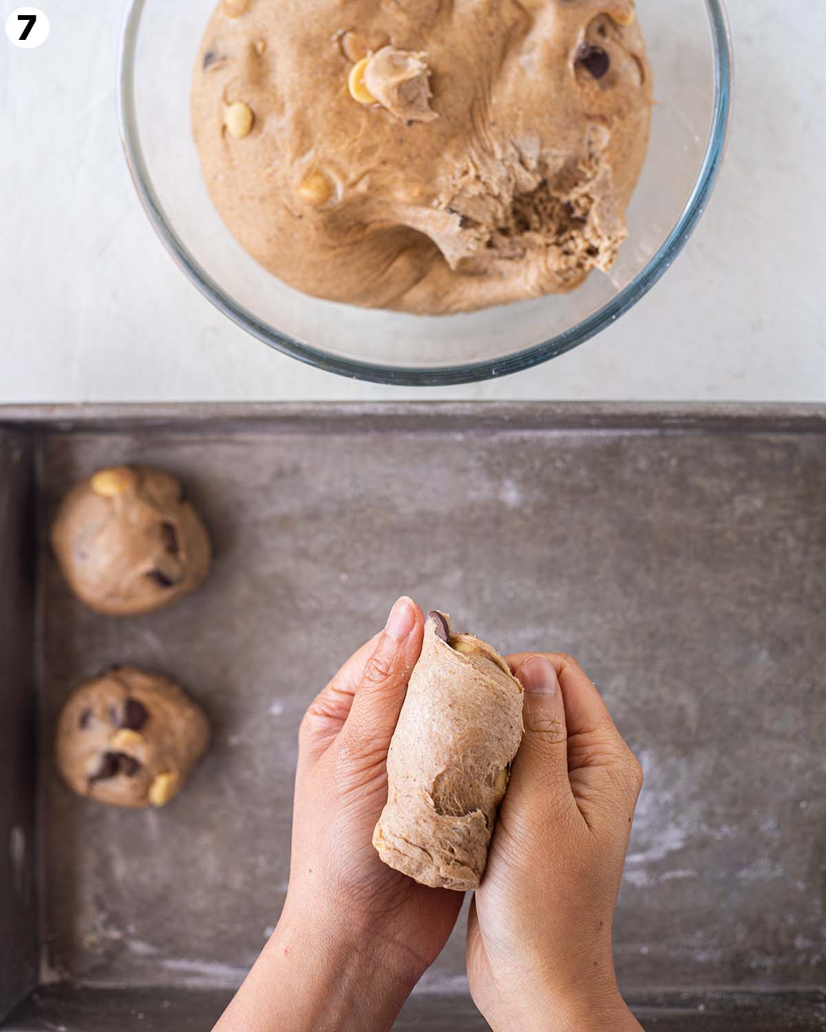 Hands shaping the hot cross buns.