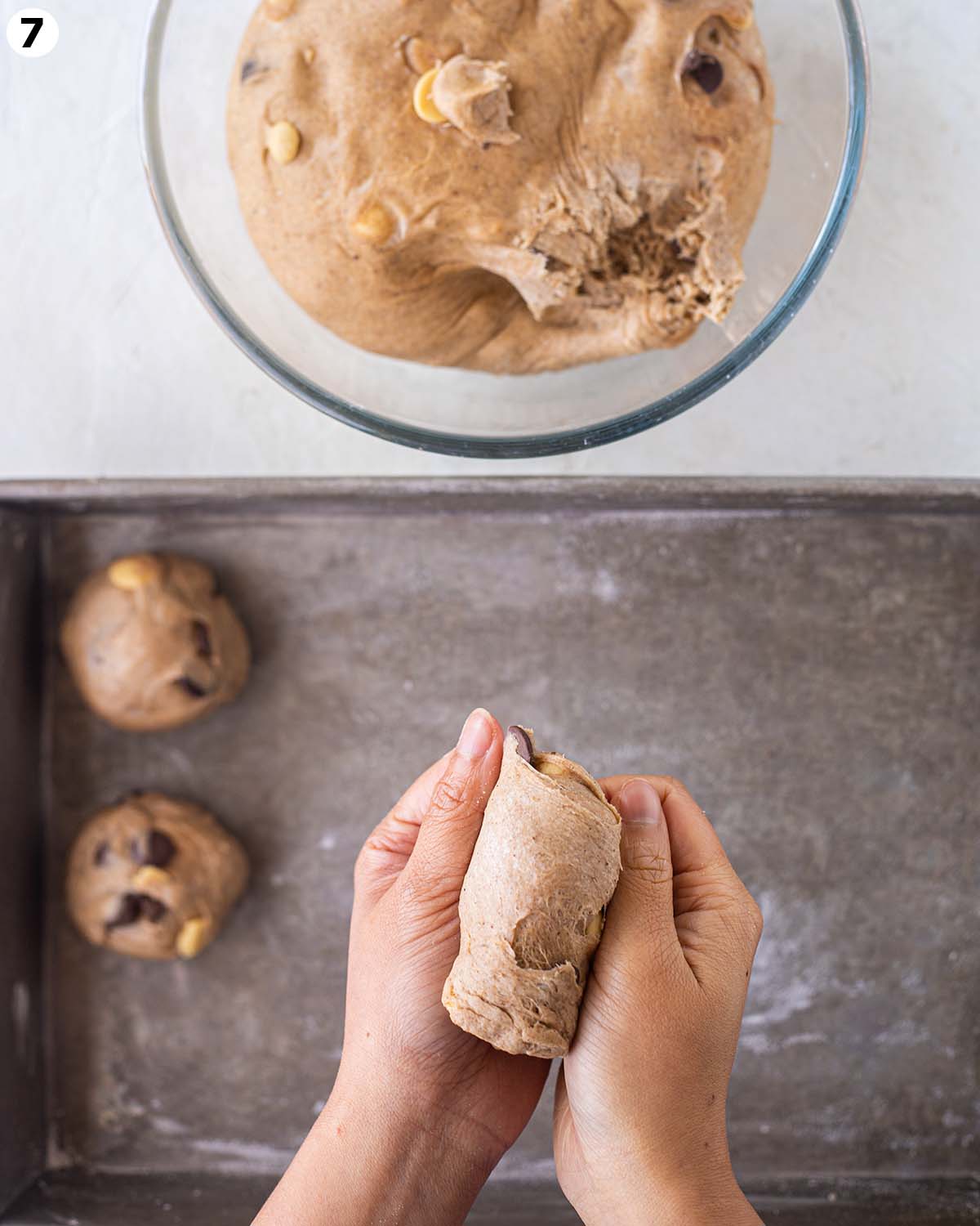 Hands shaping the hot cross buns.