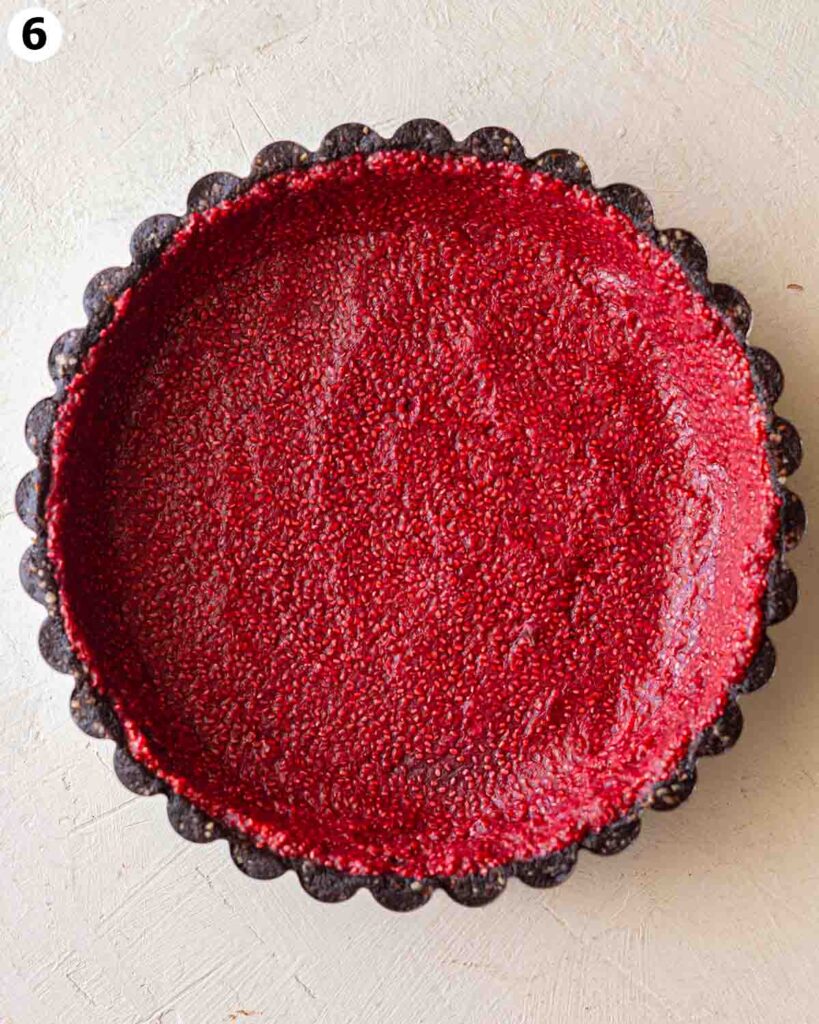 Raspberry chia jam spread on bottom and sides of chocolate tart crust.