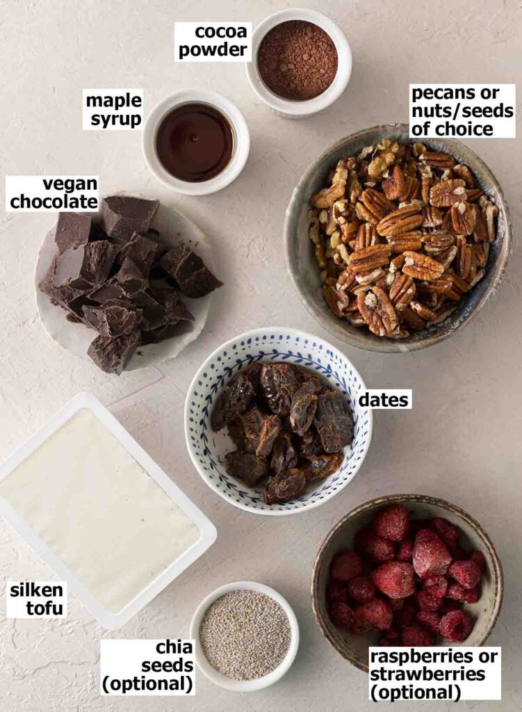 Flat lay of 8 ingredients for vegan chocolate tart.