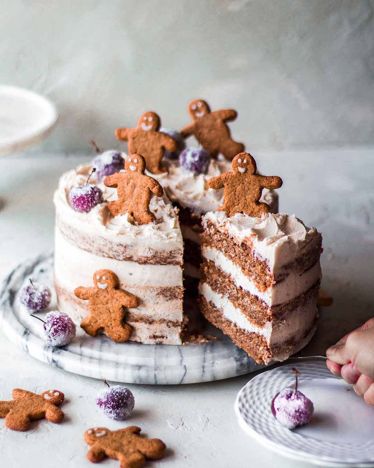 Vegan gingerbread cake made without molasses on serving board. Cake server is taking slice out showing layers.