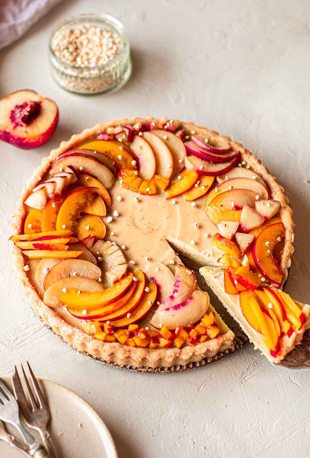 Vegan nectarine tart on plate with slice coming out.