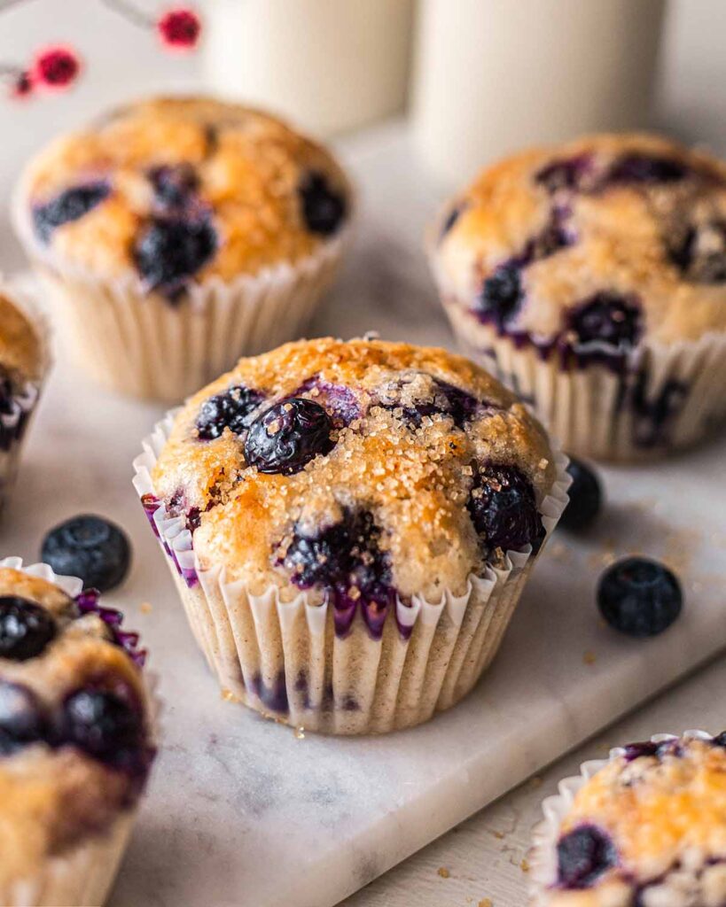 Close up of vegan blueberry muffin with coarse sugar on top.