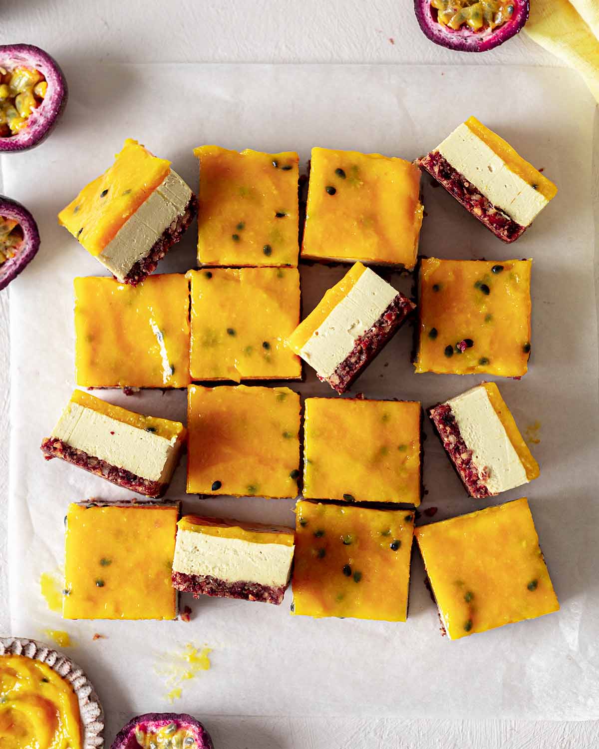 Overhead image of cheesecake bars cut into portions with a few bars on their sides revealing layers.