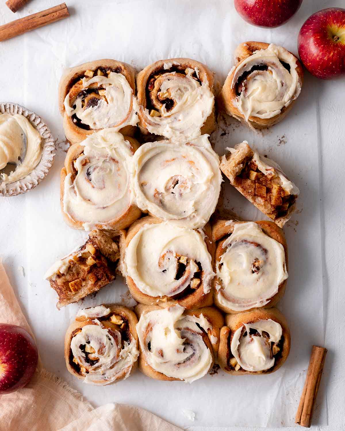 Flatlay of apple cinnamon rolls with some rolls on their side showing the apple cinnamon filling.