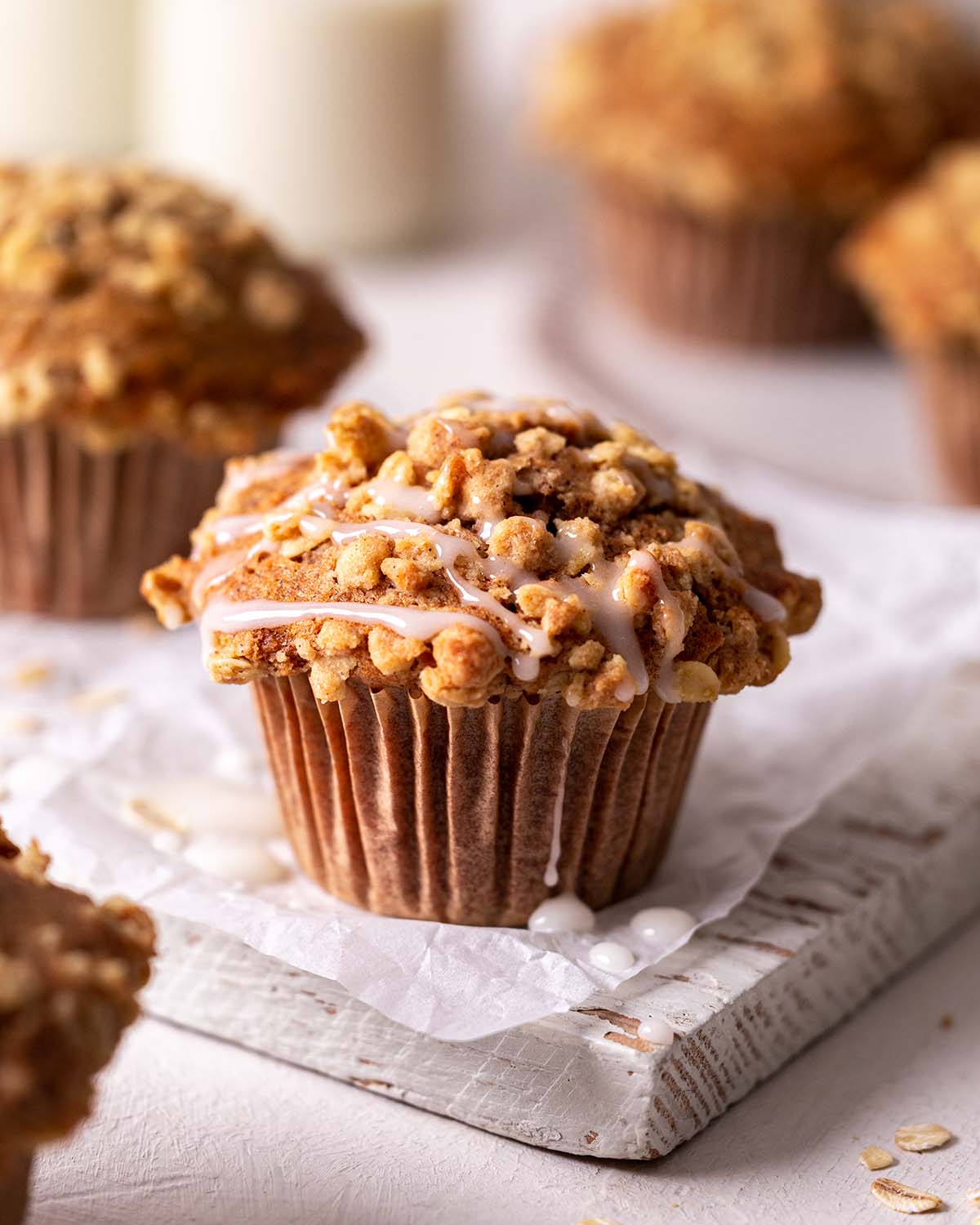 Close up of one carrot muffin with crumb topping and drizzle of icing.