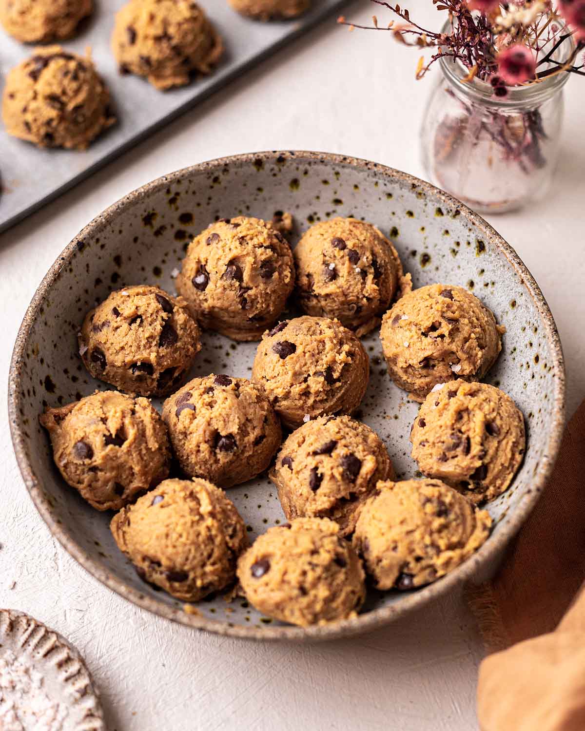 Round scoops of cookie dough in a shallow bowl.