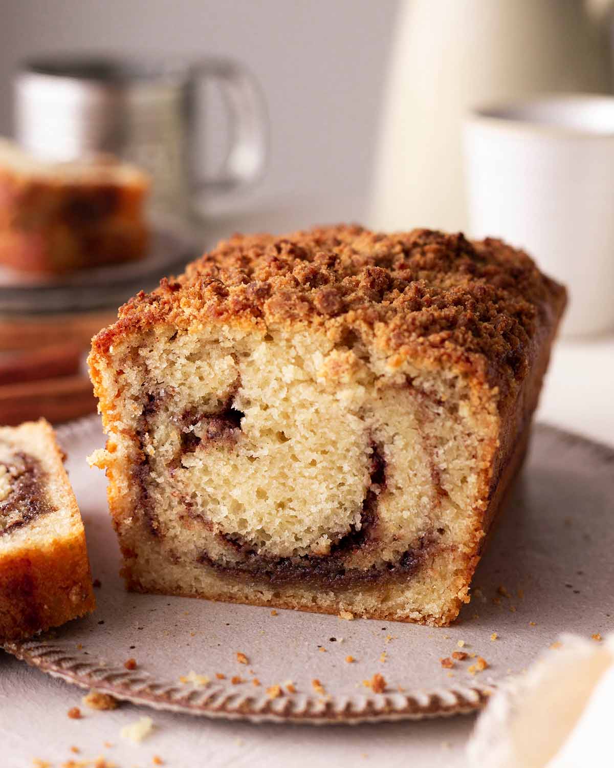 Close up of cinnamon loaf with slice cut off showing swirl pattern.