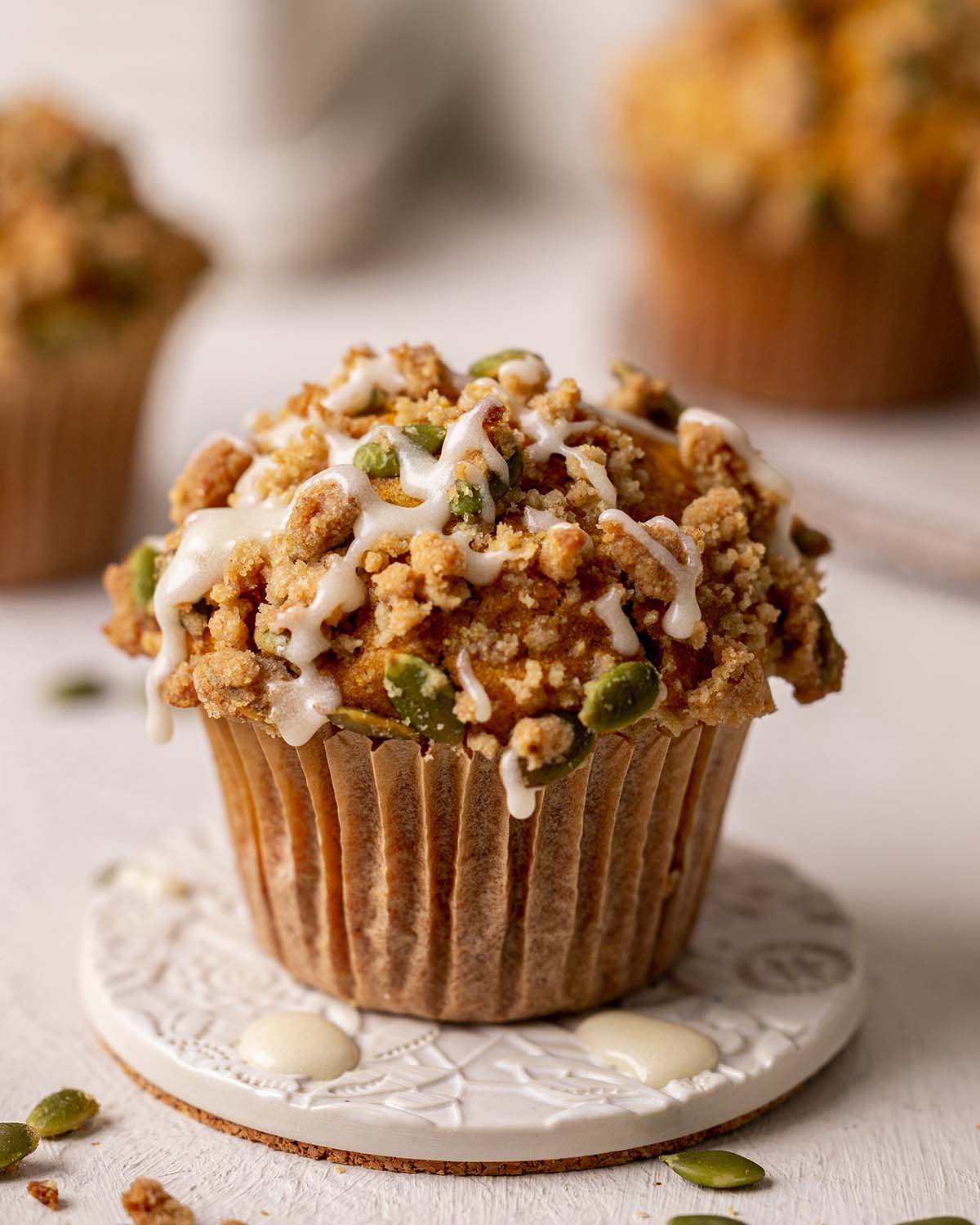 Close up of muffin with streusel topping and simple sugar icing on top.