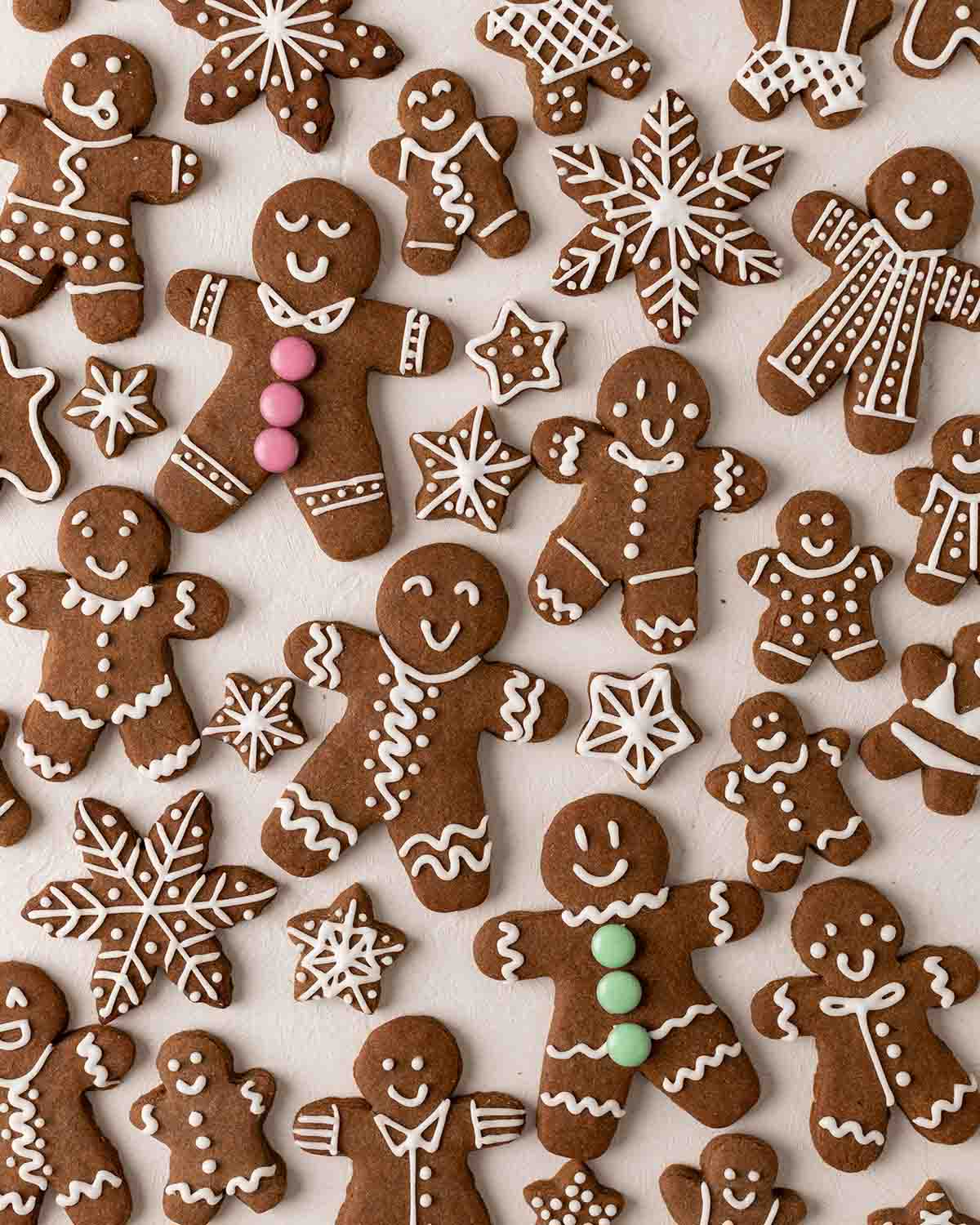 Flatlay of many vegan gingerbread cookies with varying sizes of gingerbread men and stars.