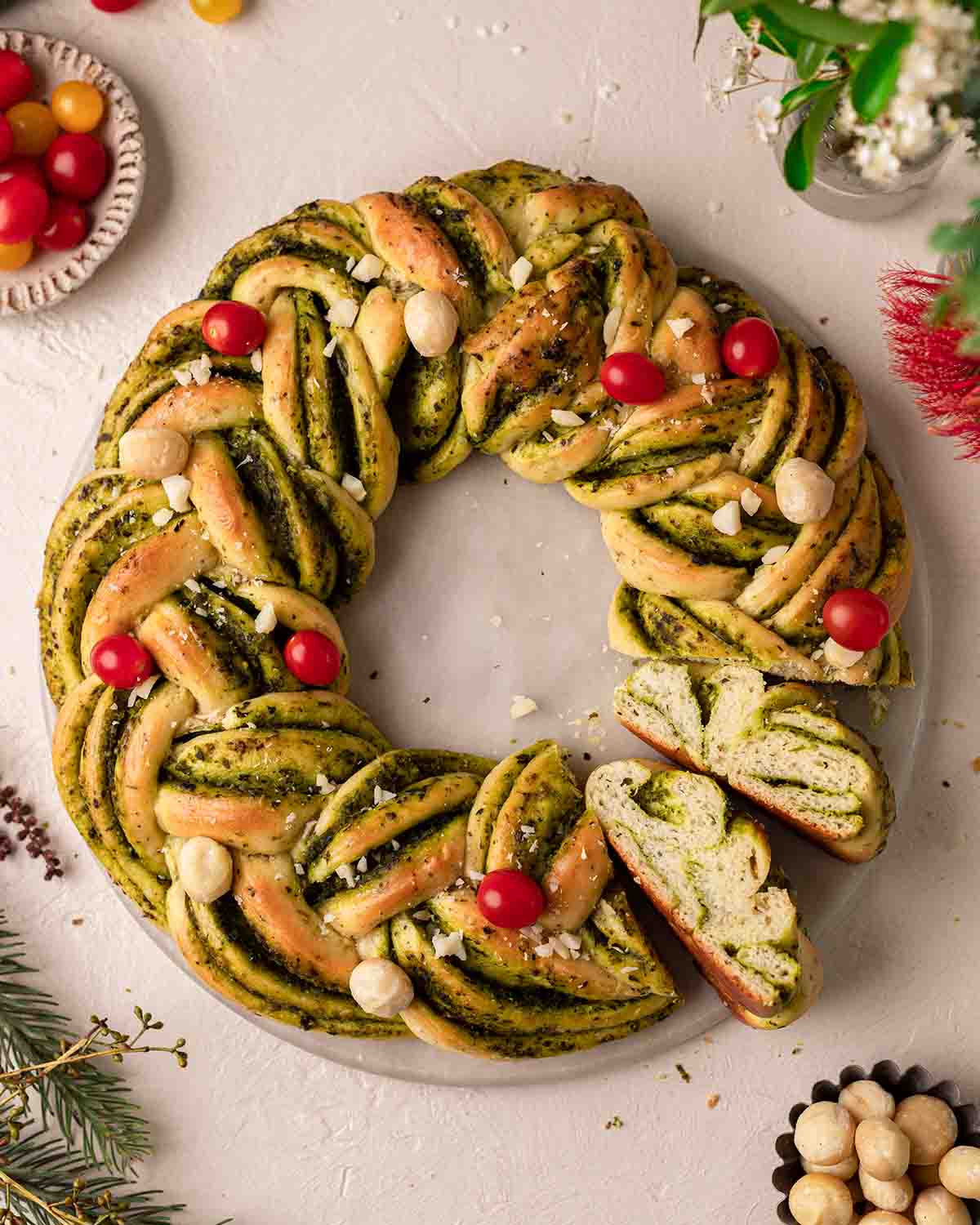 Overhead image of vegan pesto wreath with few slices coming out showing layers of pesto and bread.