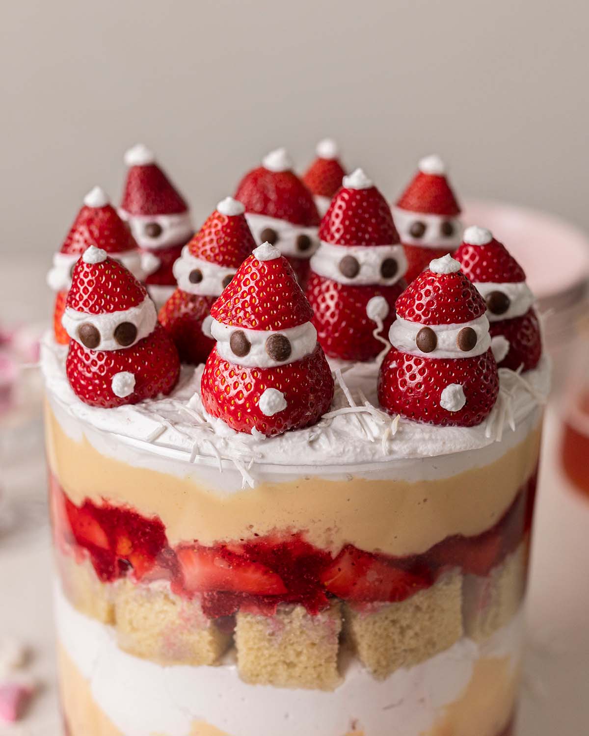 Close up of strawberry Santa sitting on top of trifle.