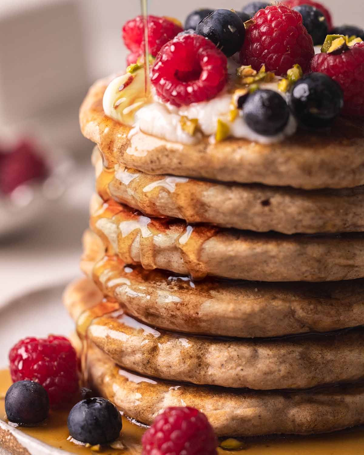 Close up of pancake stack and drizzle of maple syrup.