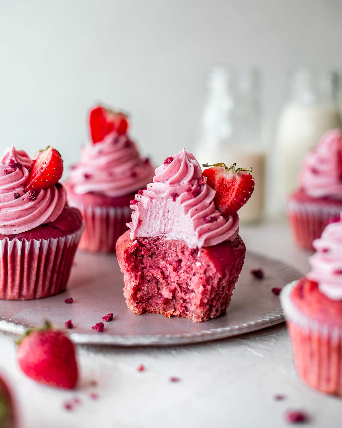 A bite shot of a vegan strawberry cupcake revealing its fluffy but moist texture.